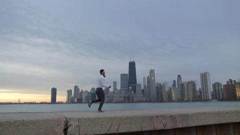 Man is running on the ebankment. Athlete training outdoors. Downtown with Stock-Footage 82647973