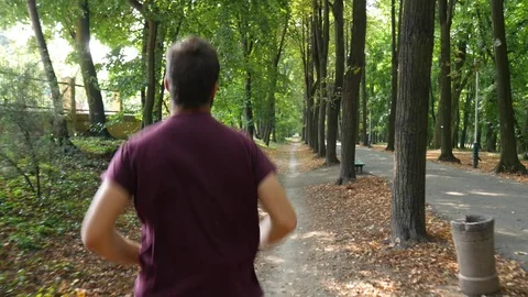 Man running on footpath in park Stock Footage 94694892
