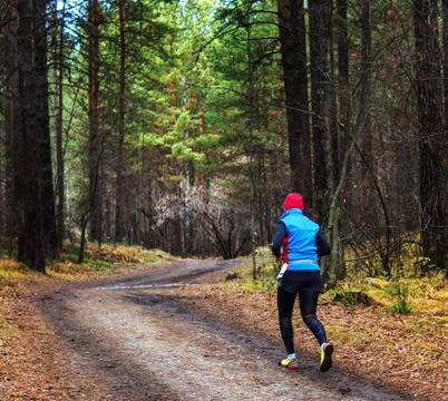 The man running in the forest. The Athletic man running on a forest trail. Photos