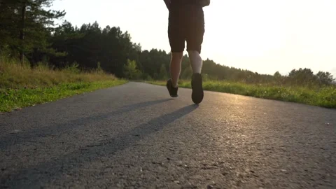 Man running in a forest park in summer at sunset Stock Footage 139677197