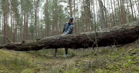 Man running on forest trail and jump over old fallen tree. slow motion slider Stock Footage 142812245