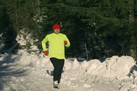 Man running in the forest at winter, steadycam shot, slow motion shot at 240fps Stock-Footage 47085956