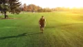 The man running on the grass in a beautiful park on the sunny background 4k or 4k+ Resolution