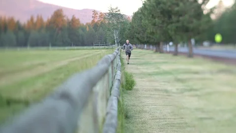 MAN RUNNING ON GRASS TOWARD CAMERA Stock Footage 80692605