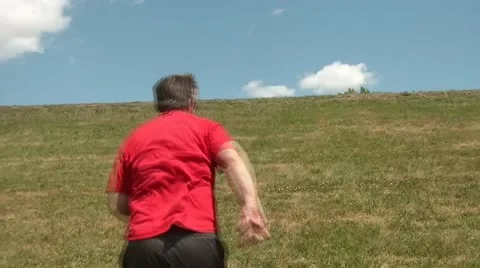 Man Running Up Hill - Into Clouds &amp; Blue Sky Stockbeeldmateriaal 12598225