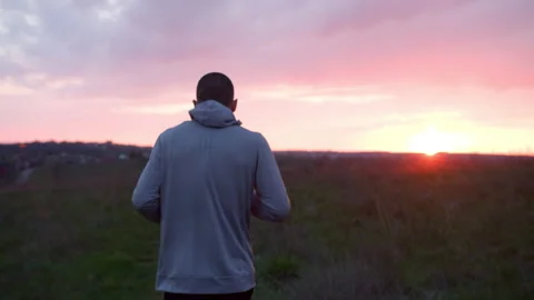 Man running in hilly countryside at sunset Stock Footage 153565426