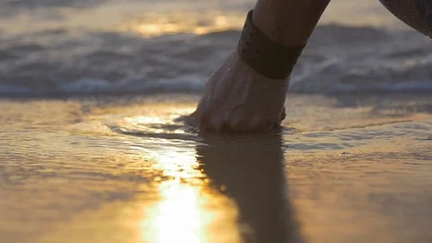 Man running his hand through the water during sunset 動画素材 128074440