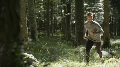 Man running - jogging through a deep wild forest Stockbeeldmateriaal 90740127