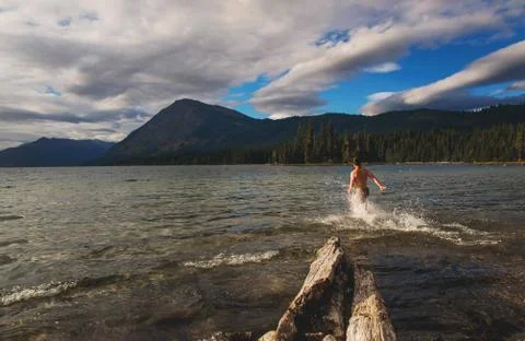 Man running into lake Stock Photos