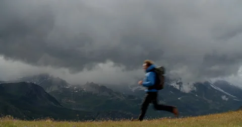 Man Running on Mountain Range as Stormy Weather Approaches. Vídeo Stock 68943770