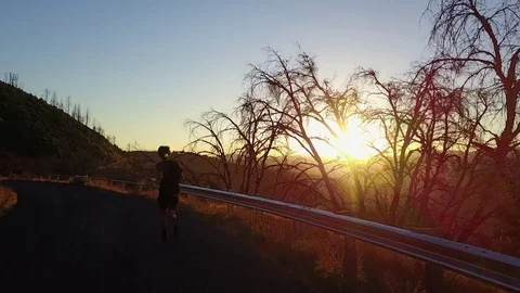 Man Running on Mountain Road at Sunset Stock Footage 83220969