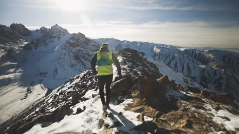 Man running at the mountain with snow Stock Footage 167600225