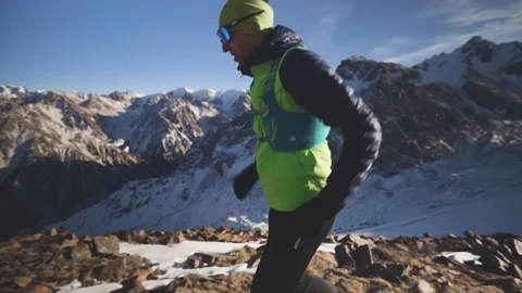 Man running at the mountain with snow Stock Footage 168276644