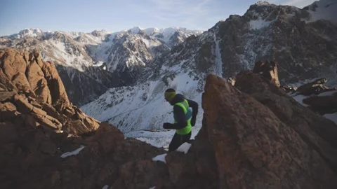 Man running at the mountain with snow Stock Footage 168277372