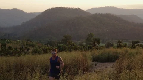 Man running in mountains of Thailand at sunset Stock Footage 79082054