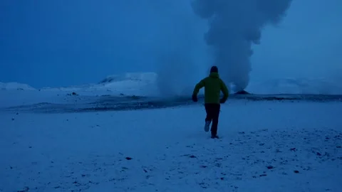 A man running into one of the steaming fumaroles at Hverir or Namafjall Stock Footage 281141468