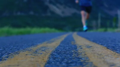 MAN RUNNING ON OPEN ROAD WITH MOUNTAIN BACKGROUND 스톡 동영상 42389233