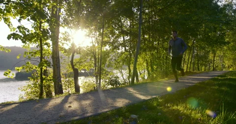 Man running in park during sun rise – slow motion Stock Footage 55327963