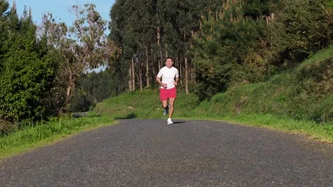 Man Running In The Path Along The Forest. - aerial pullback shot Stock Footage 310954797