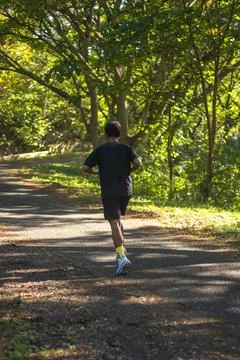 Man Running on a Path Through the Woods Stock Photos