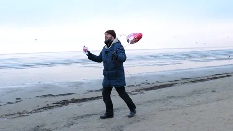 Man running to present heart shaped balloons. Valentine's Day Stock Footage 146122114