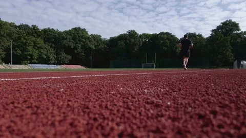 Man running at race track at stadium Stock Footage 159703091