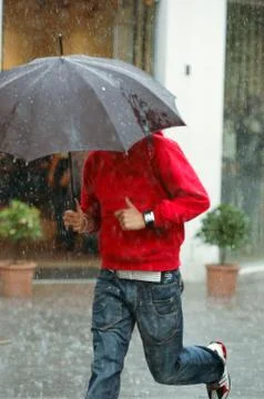 Man running in the rain. Stock Photos