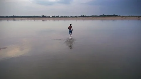 Man running in the river Stock Footage 94035691