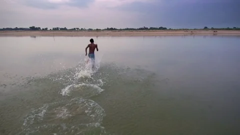 Man running in the river Stock Footage 94037103
