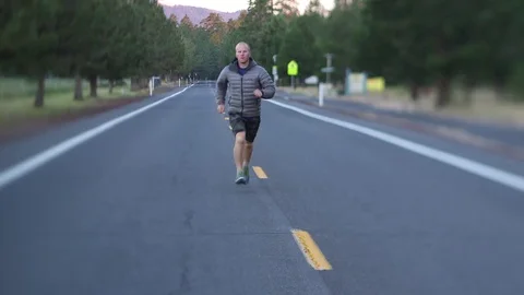 MAN RUNNING ON ROAD TOWARD CAMERA Stock Footage 80692258