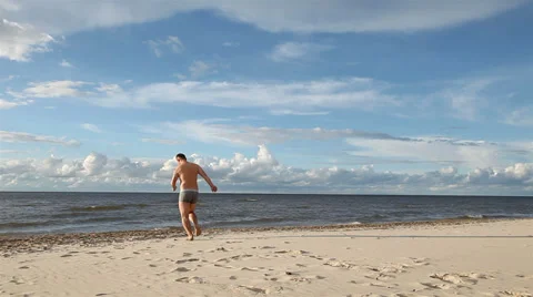 Man running into the sea Stock Footage 27486032