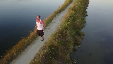 Man running by sea at sunset Stock Footage 77705812