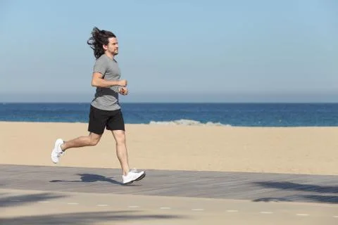 Man running on the seafront of the beach Stock Photos