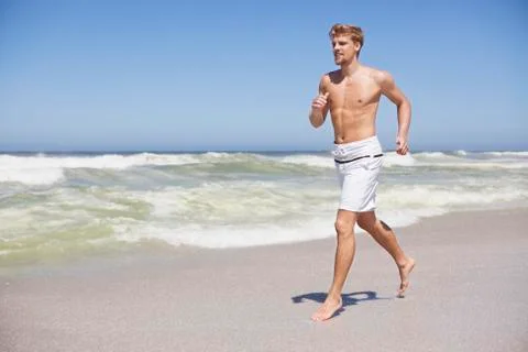 Man running shirtless on the beach Stock Photos