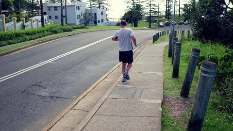Man running on sidewalk Stock Footage 74801483
