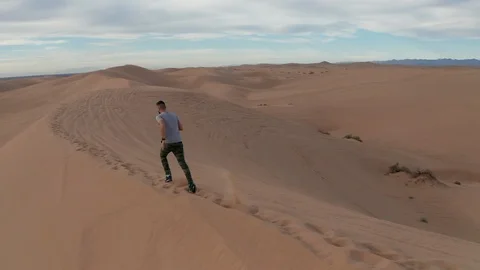 Man Running in Slow Motion in the San Dunes of San Diego, California Stock Footage 106289315