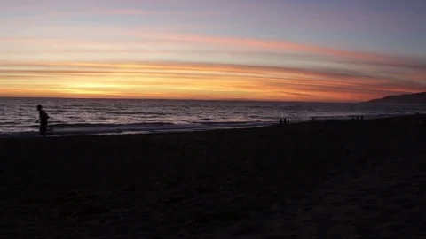 Man running on sunset beach Stock Footage 82549757
