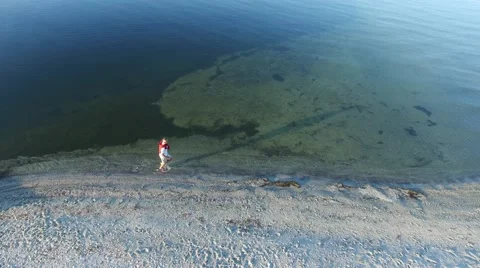 Man running in the surf along the sandy beach Video stock 67866485