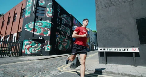 Man running through city streets. Vídeo Stock 67640232