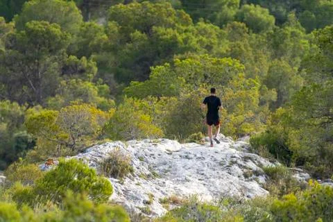 Man running through the mountain. Stock Photos