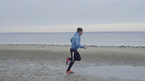 A man running through mud and puddles on a morning run Stock Footage 221563854