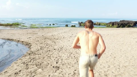 Man Running Towards Ocean Beach Vibrant Colours Stock Footage 120052203