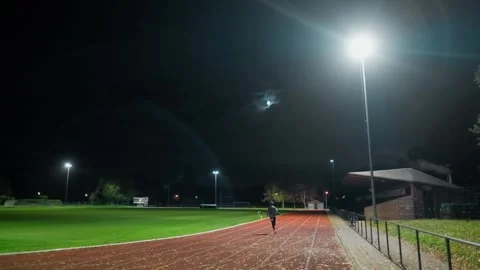Man running on a track at night Stock Footage 289290588