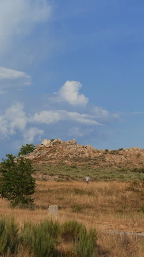 Man Running on Trail Across Dry Grass and Hills Video stock 345607049