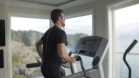 Man running on a treadmill at the gym, physical fitness, working out, determined Vídeos de archivo 230197446