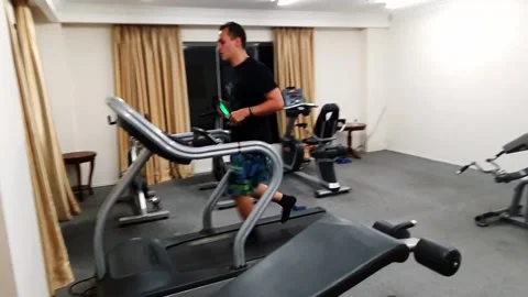 Man running on a treadmill in a hotel 스톡 동영상 204764235