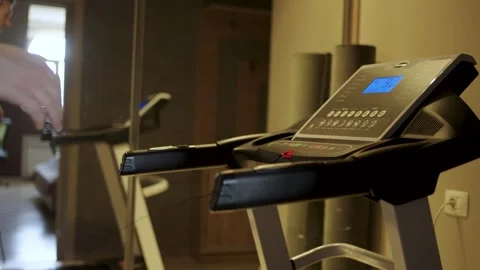 Man Running on Treadmill with Red Emergency Safety Key. Close-up of a man r.. Stock Footage 332335180