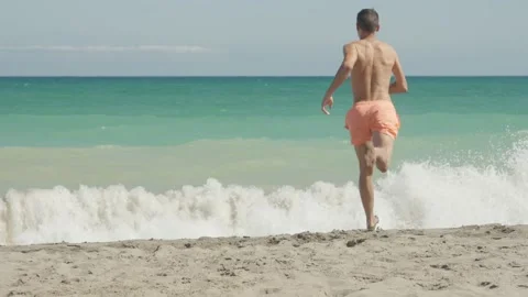 Man running to the water of the ocean Stock Footage 219722206