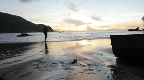Man running into waves at sunset in tobago (HD)c  Stock Footage 12656947