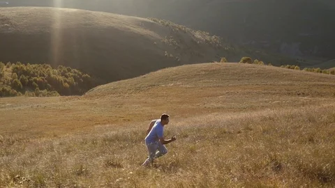 Man runs across the field the setting sun Stock Footage 95493500